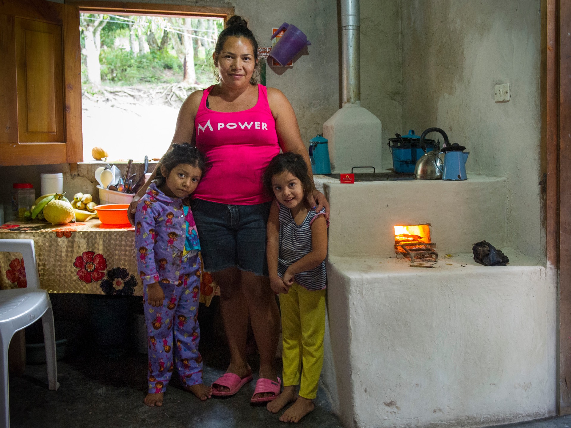 A mother and her children in front of their new cookstove in Honduras.